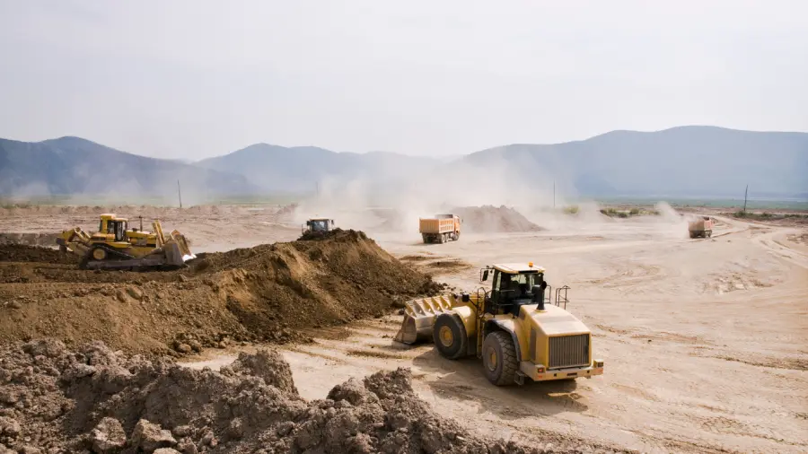 E4H image of a construction sight of moving trucks digging and moving dirt